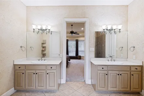 a spacious bathroom with a double vanity sink a large mirror a bathtub and