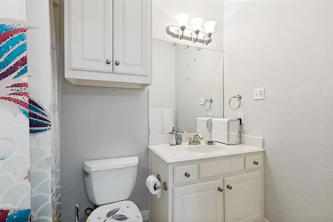 a bathroom with a sink a toilet and mirror