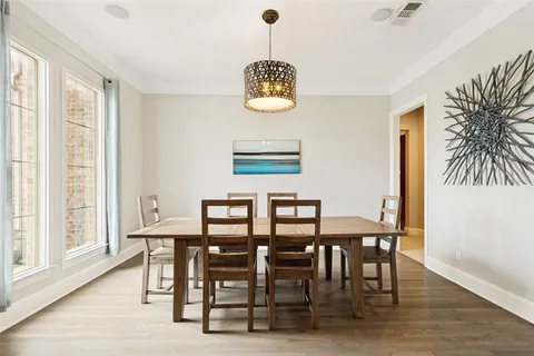 a dining room with furniture window and wooden floor