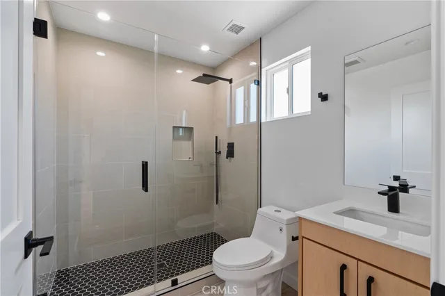 a bathroom with a sink toilet vanity and shower
