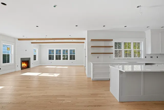 a view of empty room with wooden floor and fireplace