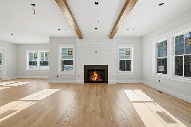 a view of an empty room with a window and fireplace