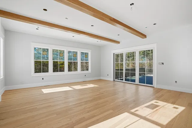 a dining room with wooden floor and glass windows