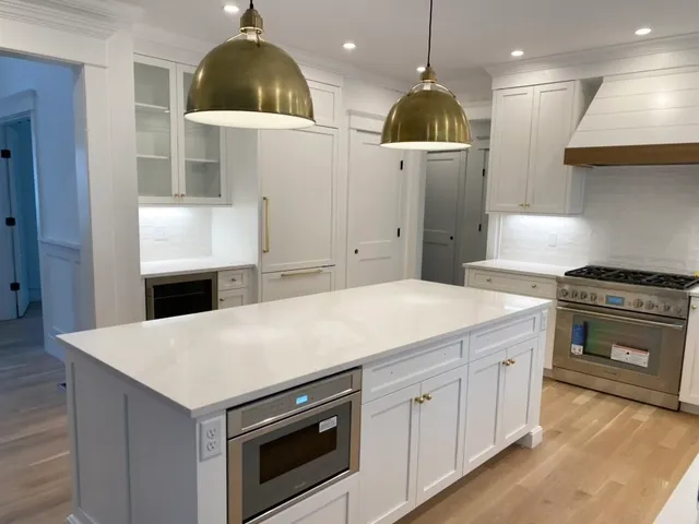 a kitchen with kitchen island a stove a counter space a sink and a fireplace
