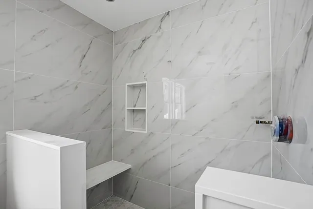 a view of a kitchen with white cabinets and a window