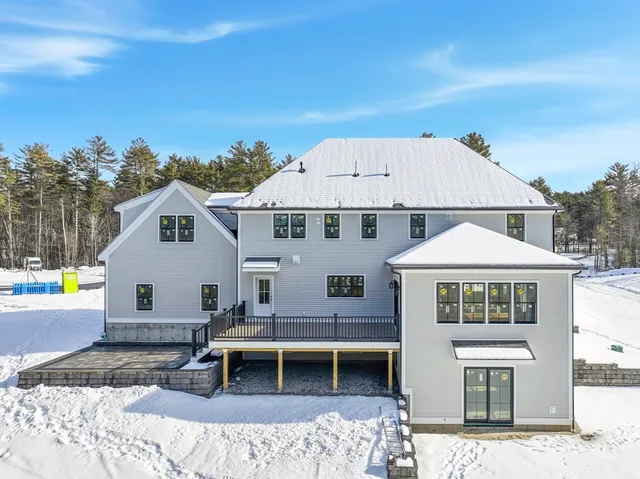 a front view of a house with a yard covered with snow in front of house