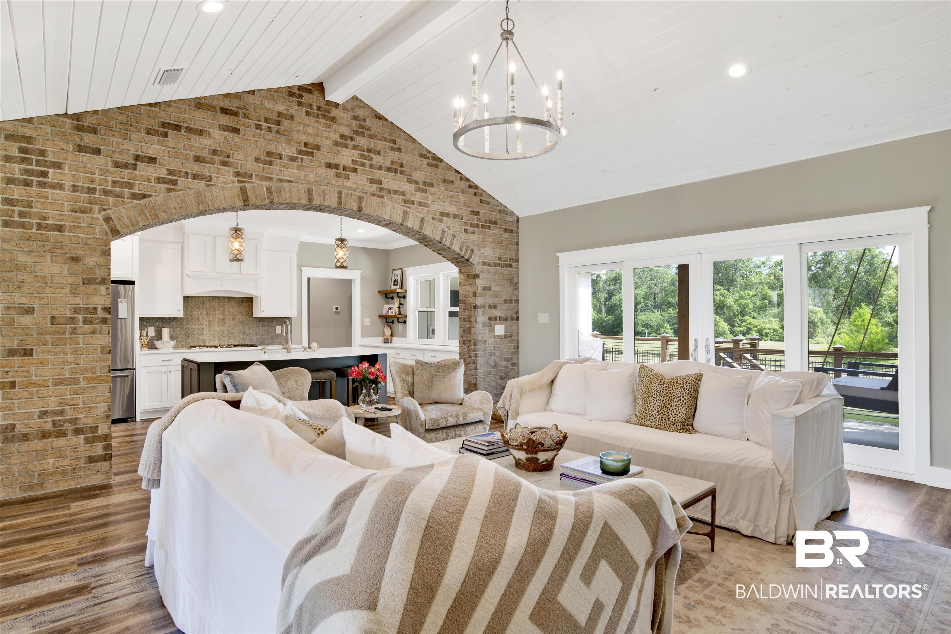 21621 Veranda Boulevard Fairhope, AL 36532 - Photo 38 of 51 Living room with visible vents, arched walkways, wood finished floors, beamed ceiling, and a notable chandelier