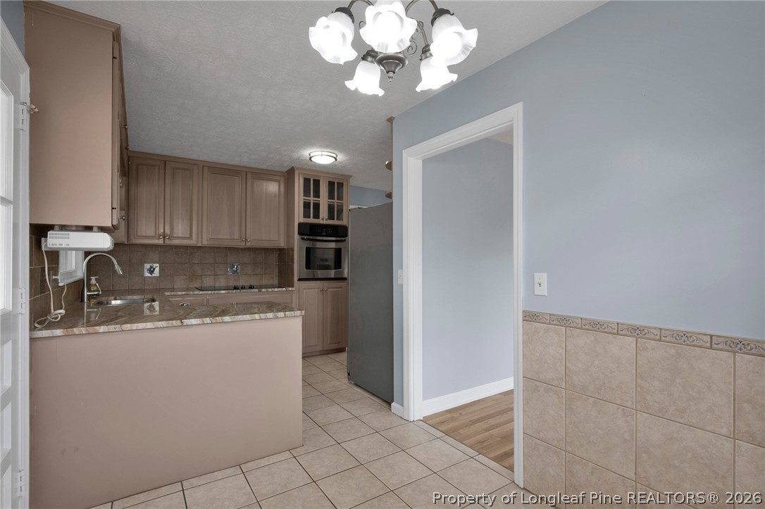 1064 Bainbridge Road Stedman, NC 28391 - Photo 14 of 46 a kitchen with stainless steel appliances granite countertop a sink a stove top oven and cabinets