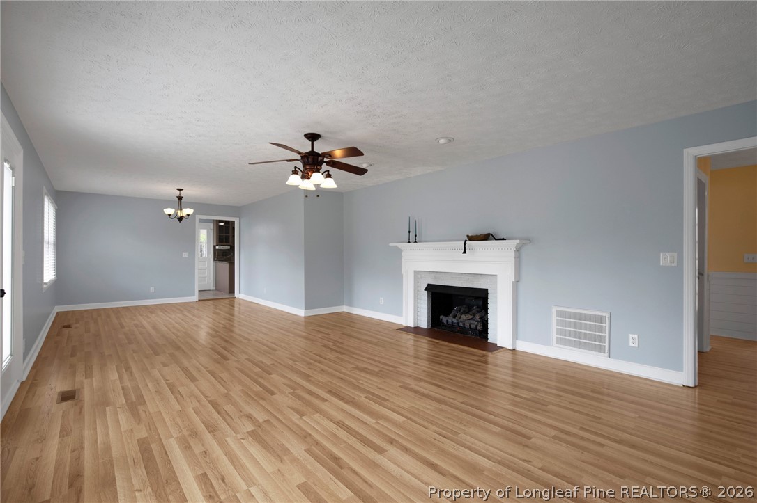 1064 Bainbridge Road Stedman, NC 28391 - Photo 19 of 46 a view of an empty room with wooden floor fireplace and a window