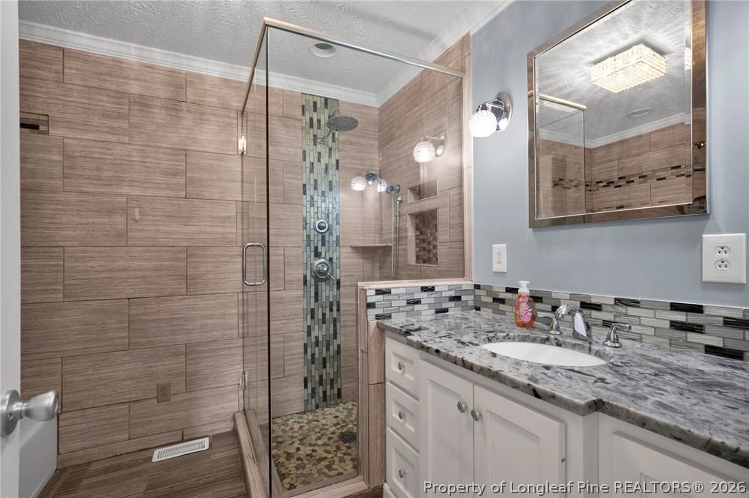 1064 Bainbridge Road Stedman, NC 28391 - Photo 29 of 46 a bathroom with a granite countertop sink a mirror a glass door shower and vanity