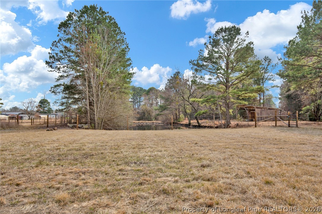 1064 Bainbridge Road Stedman, NC 28391 - Photo 40 of 46 a wooden bench sitting in middle of a yard