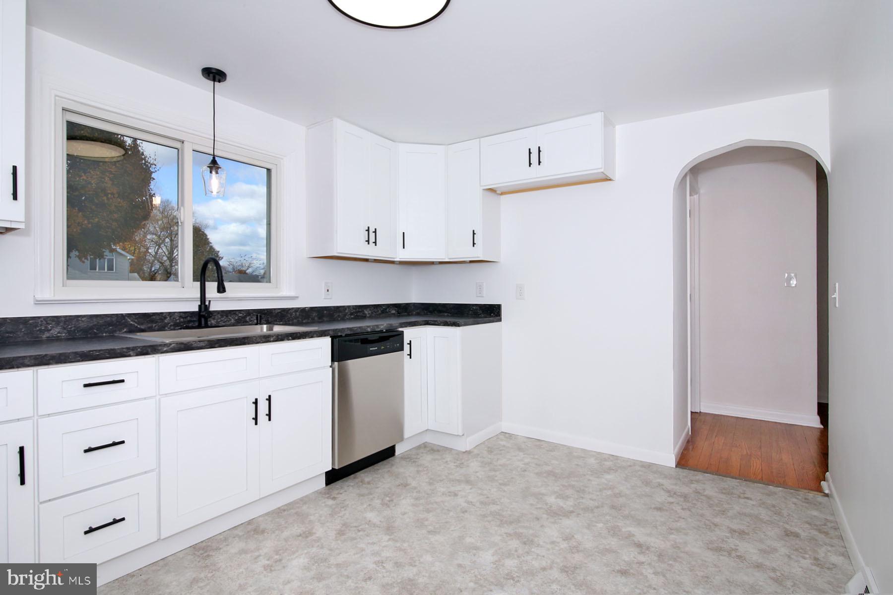 1011 State Drive Lebanon, PA 17042 - Photo 13 of 34 a kitchen with white cabinets a sink a window and stainless steel appliances