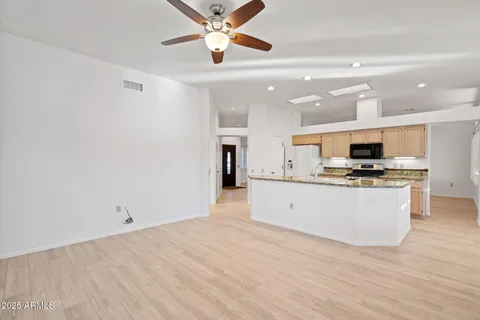 a large kitchen with stainless steel appliances a large window a oven and a counter space