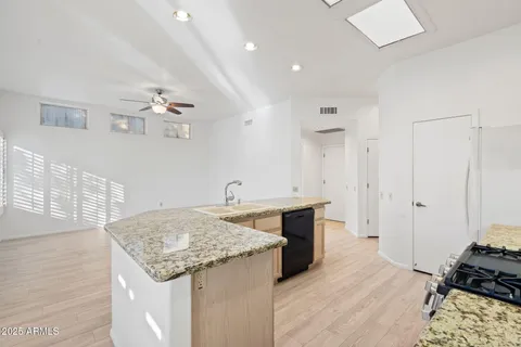 a kitchen with stainless steel appliances granite countertop a sink stove and refrigerator