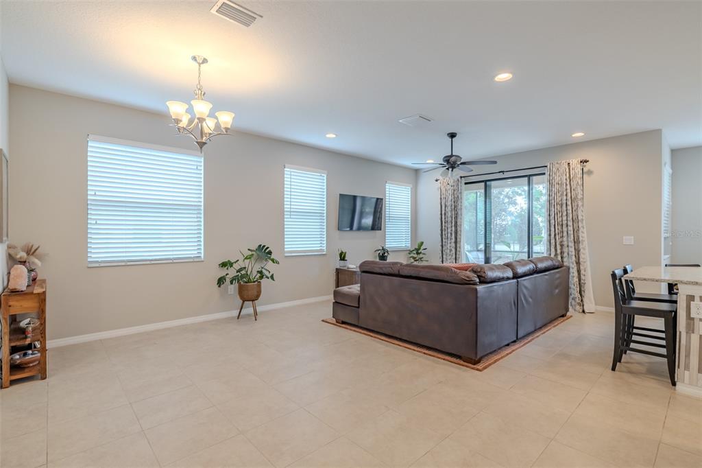 4730 Wandering Way Wesley Chapel, FL 33544 - Photo 16 of 61 a living room with furniture and a chandelier