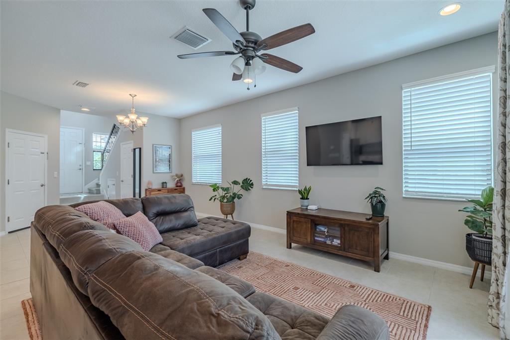 4730 Wandering Way Wesley Chapel, FL 33544 - Photo 19 of 61 a living room with furniture and a flat screen tv