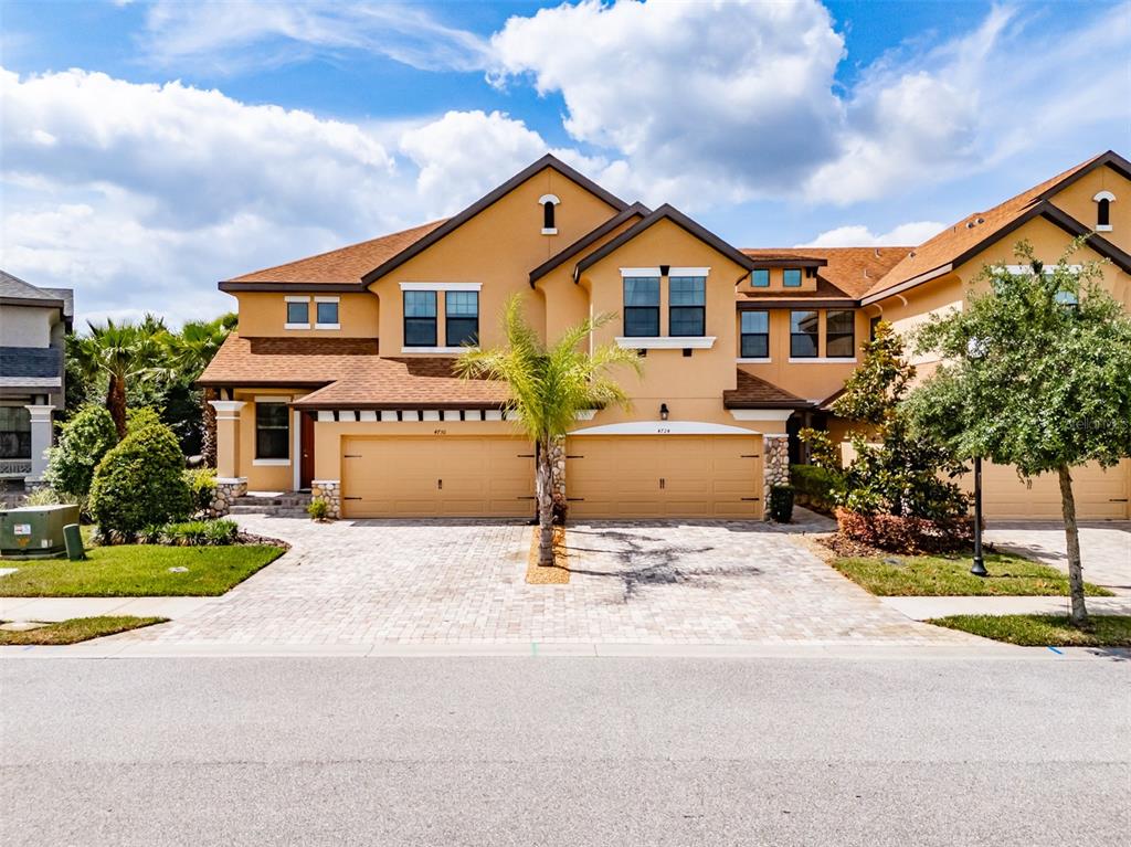 4730 Wandering Way Wesley Chapel, FL 33544 - Photo 54 of 61 a front view of a house with a yard and garage