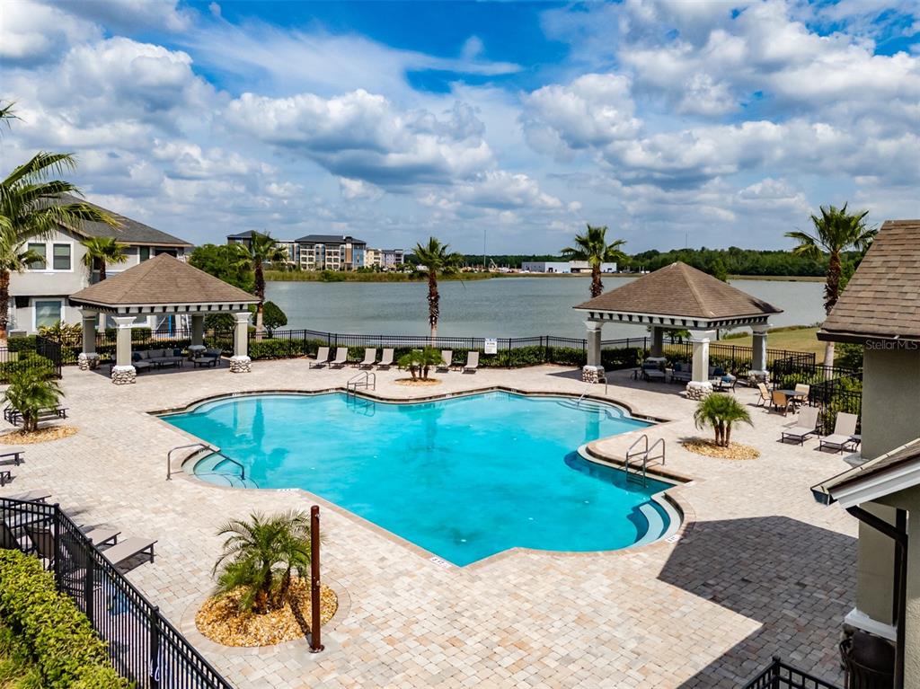 4730 Wandering Way Wesley Chapel, FL 33544 - Photo 58 of 61 an aerial view of a house having swimming pool patio and lake view