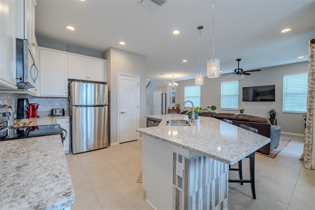 4730 Wandering Way Wesley Chapel, FL 33544 - Photo 6 of 61 a kitchen with stainless steel appliances granite countertop a sink refrigerator and microwave