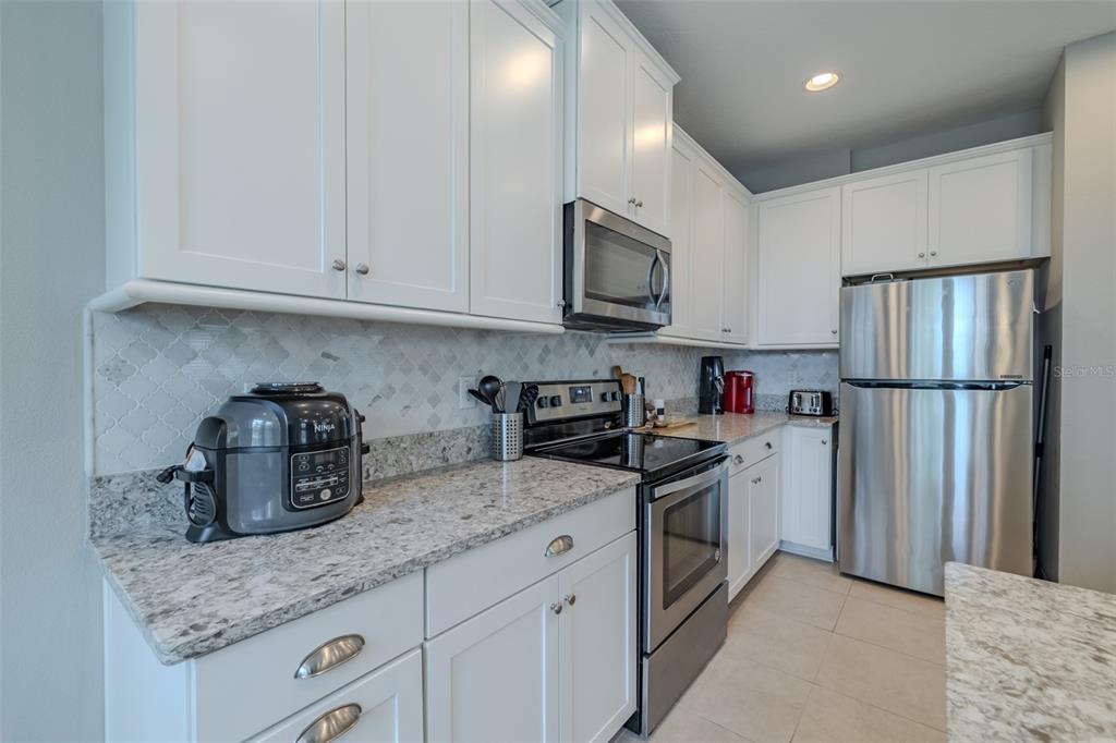 4730 Wandering Way Wesley Chapel, FL 33544 - Photo 9 of 61 a kitchen with granite countertop a refrigerator stove and sink
