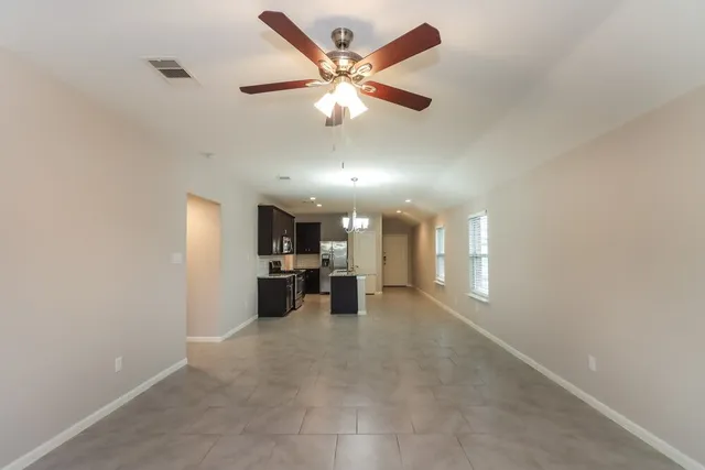 wooden view of a livingroom with a ceiling fan and a rug
