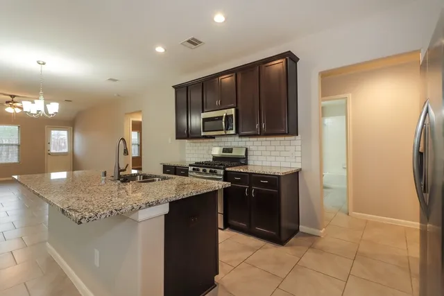 a kitchen with stainless steel appliances granite countertop a sink stove and refrigerator