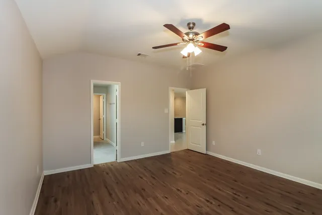 a view of empty room with wooden floor