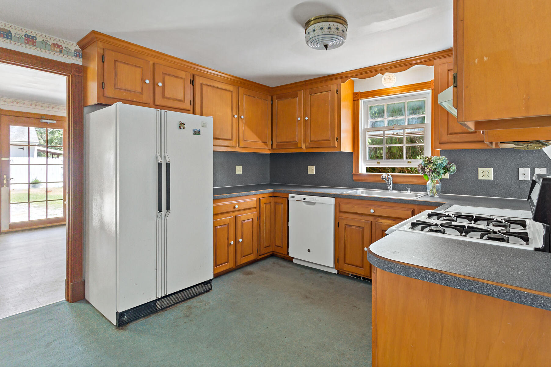426 Old Post Road Cotuit, MA 02635 - Photo 3 of 27 a kitchen with a refrigerator a sink and cabinets