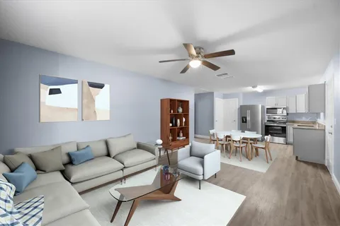 a living room with furniture kitchen view and a window