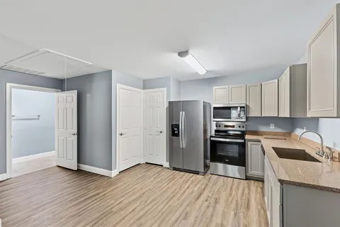 a kitchen with stainless steel appliances a refrigerator sink and microwave