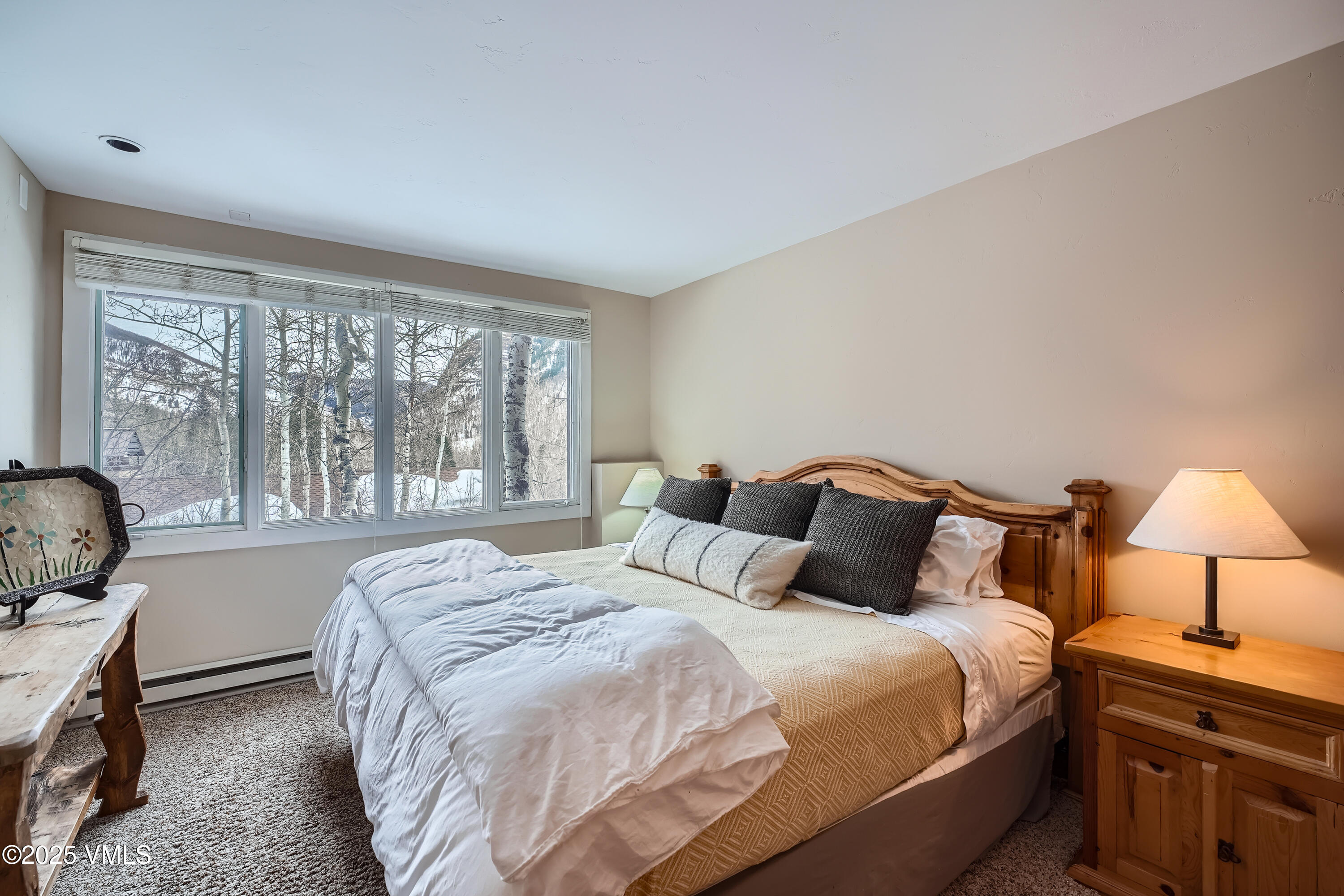 2875 Manns Ranch Road, Unit J2 Vail, CO 81657 - Photo 22 of 25 a bedroom with a bed a lamp and a large window