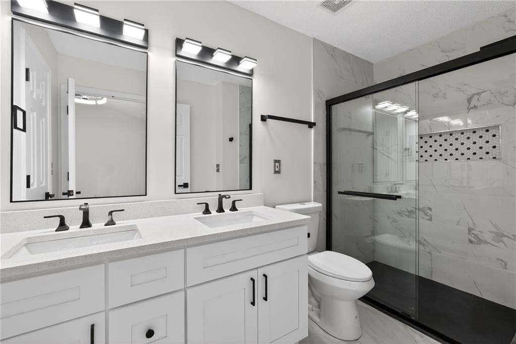 4166 Howell Park Road Duluth, GA 30096 - Photo 12 of 24 a bathroom with a sink a toilet and shower