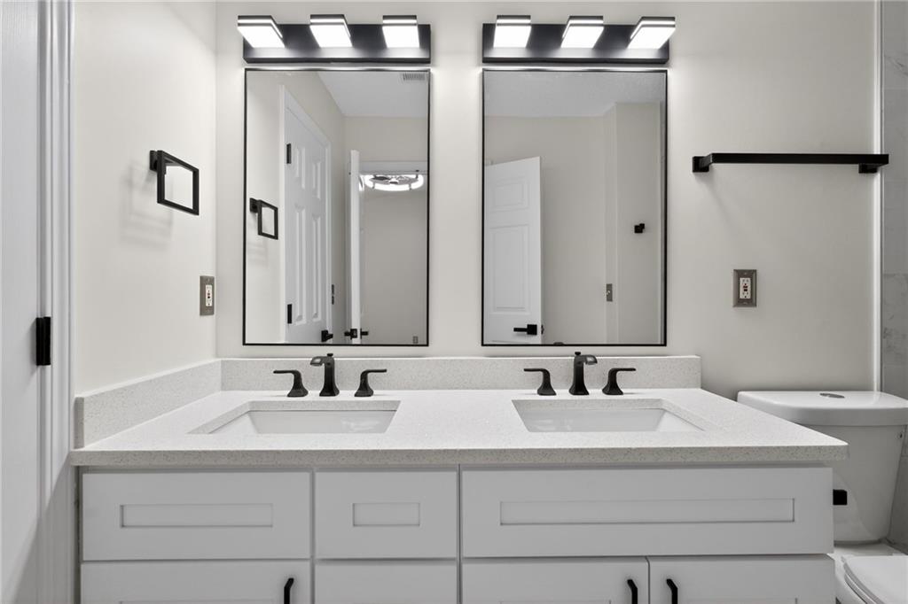 4166 Howell Park Road Duluth, GA 30096 - Photo 13 of 24 a bathroom with double vanity sinks and a mirror