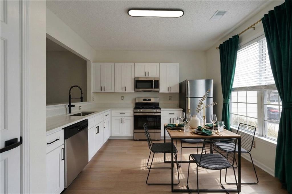4166 Howell Park Road Duluth, GA 30096 - Photo 21 of 24 a kitchen with a sink white cabinets and stainless steel appliances