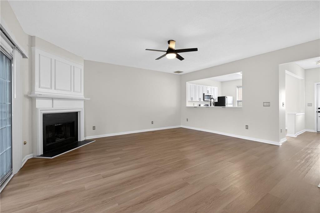 4166 Howell Park Road Duluth, GA 30096 - Photo 3 of 24 a view of empty room with wooden floor and fireplace