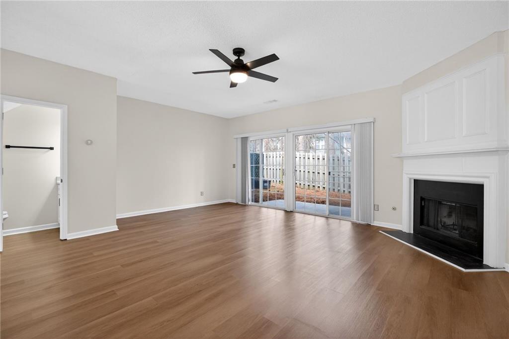 4166 Howell Park Road Duluth, GA 30096 - Photo 4 of 24 a view of an empty room with wooden floor fireplace and a window