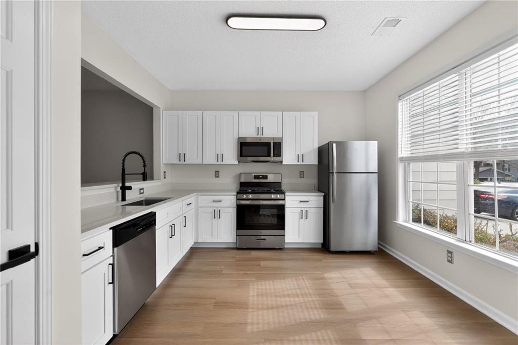 4166 Howell Park Road Duluth, GA 30096 - Photo 6 of 24 a kitchen with refrigerator a sink and a stove