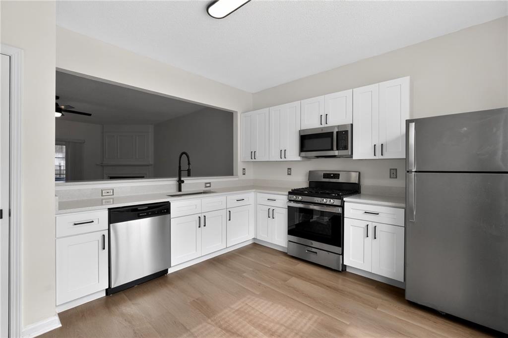 4166 Howell Park Road Duluth, GA 30096 - Photo 7 of 24 a kitchen with granite countertop white cabinets and stainless steel appliances