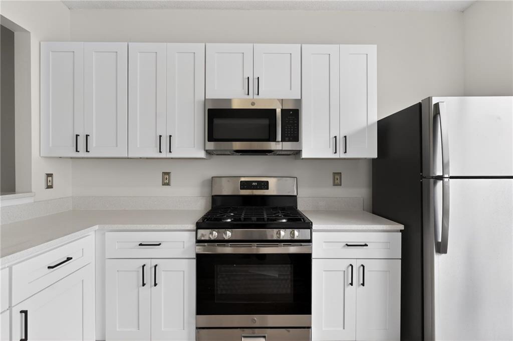 4166 Howell Park Road Duluth, GA 30096 - Photo 8 of 24 a kitchen with stainless steel appliances white cabinets and a stove a refrigerator with white cabinets