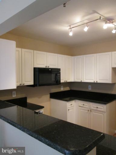 5565 Seminary Road, Unit 213 Falls Church, VA 22041 - Photo 2 of 8 a living room with stainless steel appliances kitchen island granite countertop a stove a sink and a microwave