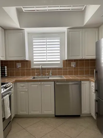 a room with granite countertop a sink and a stove
