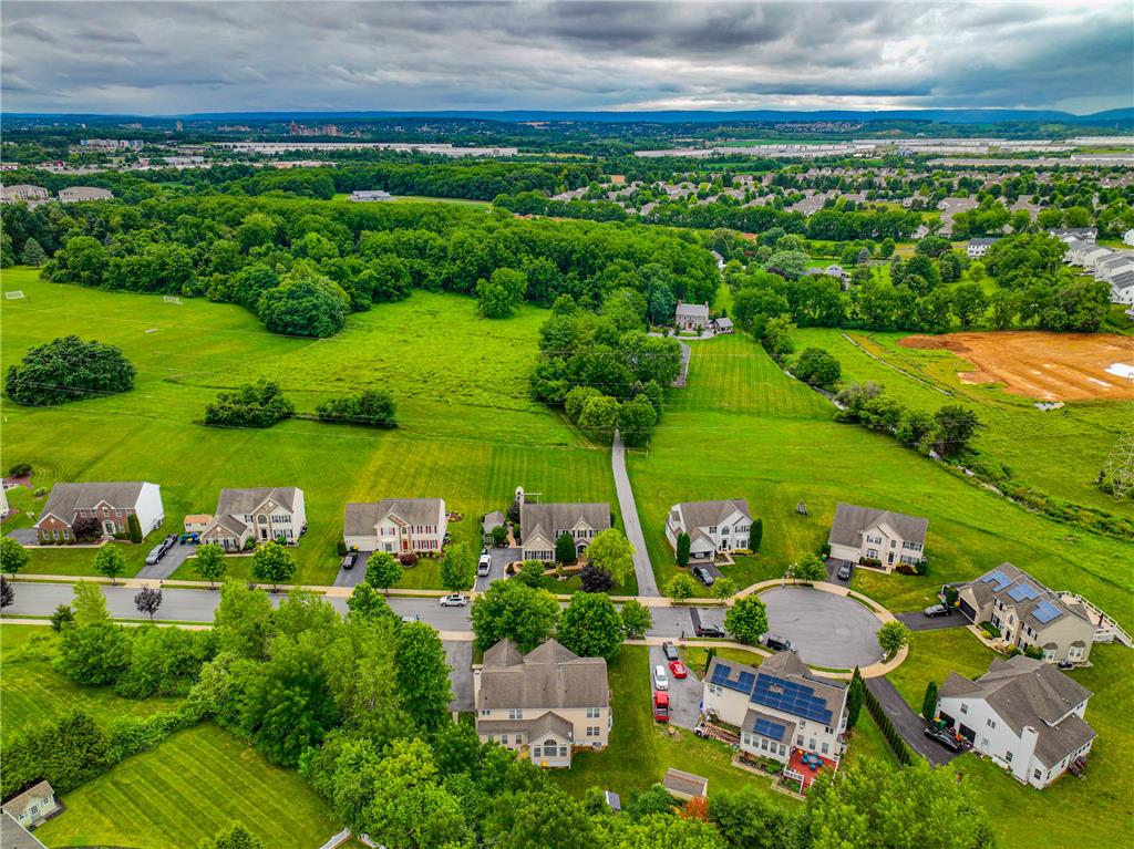 138 Clover Hollow Road Easton, PA 18045 - Photo 86 of 95 An aerial panorama reveals a peaceful suburban neighborhood surrounded by expansive green fields and distant trees.