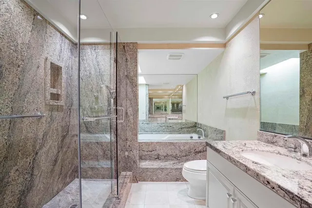 a bathroom with a granite countertop sink toilet and shower