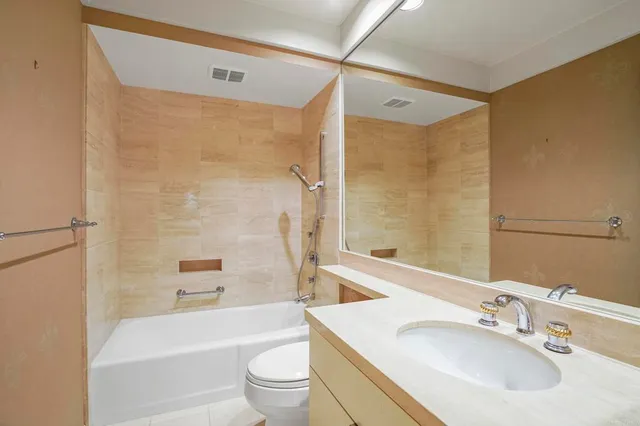 a bathroom with a sink mirror toilet and bathtub