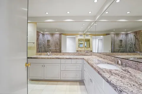 a bathroom with a granite countertop sink mirror and double
