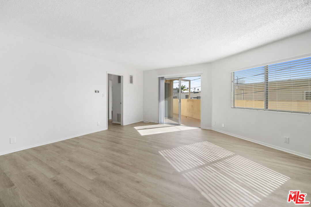 1236 McClellan Drive Los Angeles, CA 90025 - Photo 5 of 13 a view of an empty room with window and wooden floor