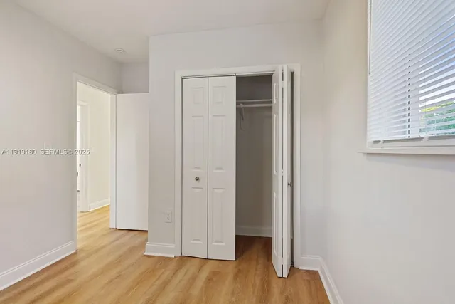 a view of a room with wooden floor and closet