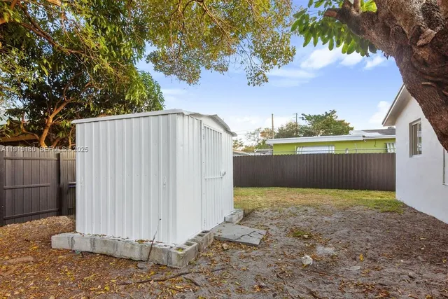 a view of backyard with deck and wooden fence