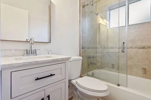 a bathroom with a granite countertop toilet a sink and a bathtub