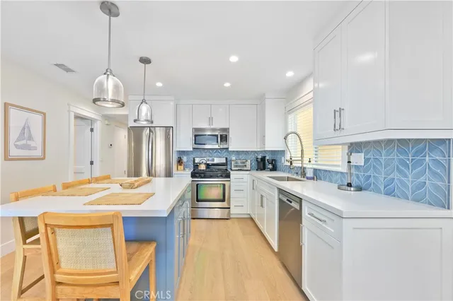 a kitchen with granite countertop a sink stove and white cabinets